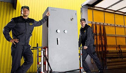 Zwei Mitarbeiter beim Transport eines Safes