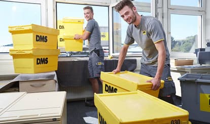 Mitarbeiter verstauen Büromaterial sicher in Transportboxen